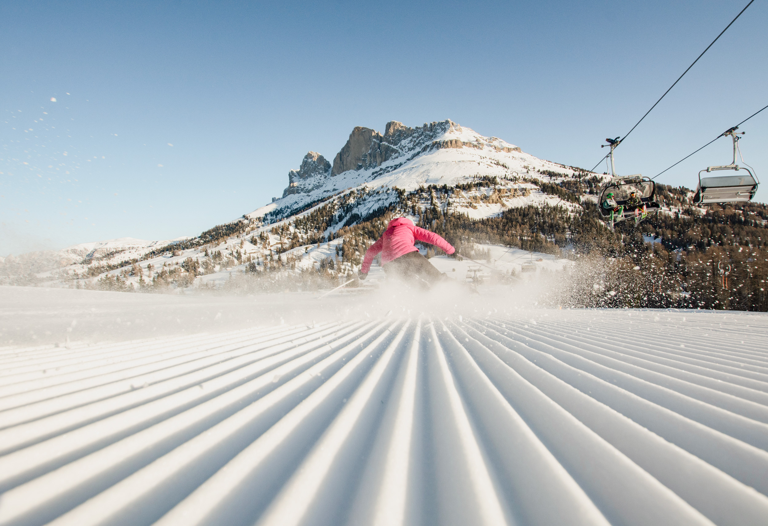 Frau fährt Ski auf frisch präparierter Piste im Eggental