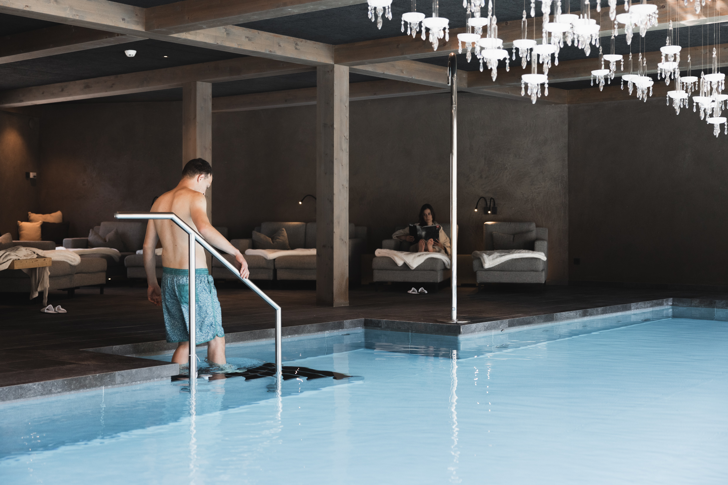 Ein Mann läuft in den Pool im Wellnessbereich des Hotel Mondschein in den Dolomiten